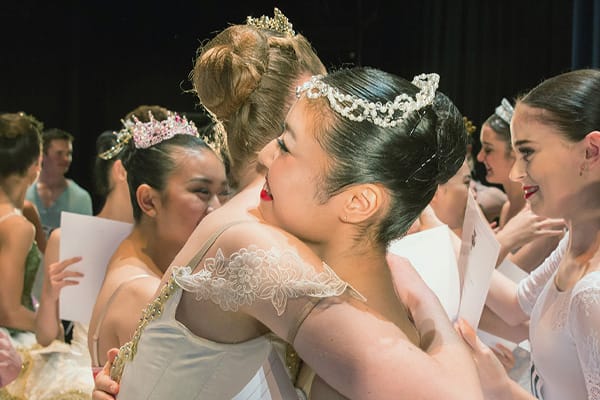 two ballerinas hugging backstage after performance